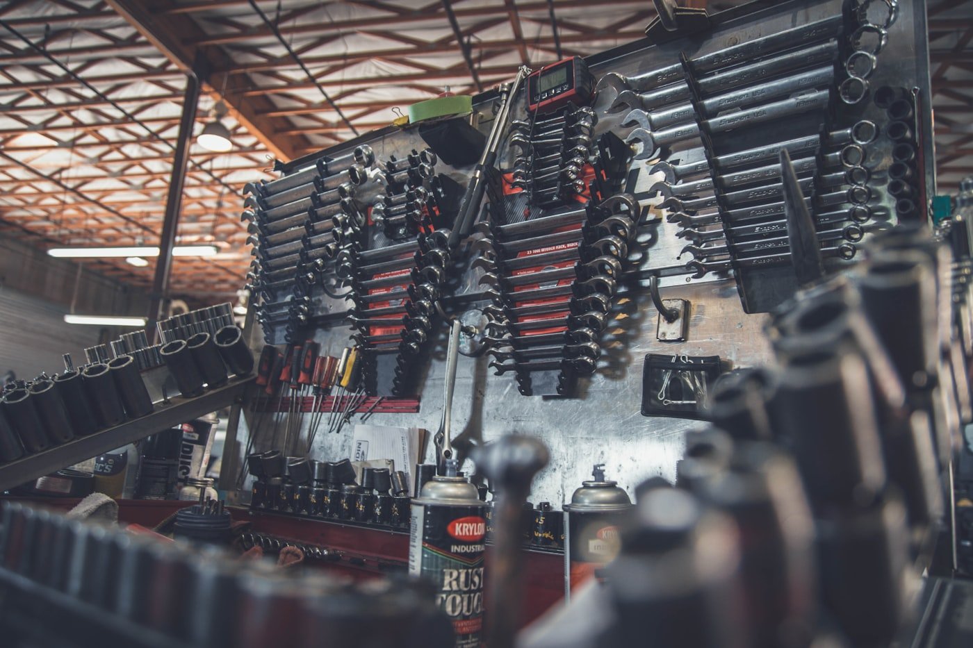 Technician inspecting a part in a busy auto parts warehouse